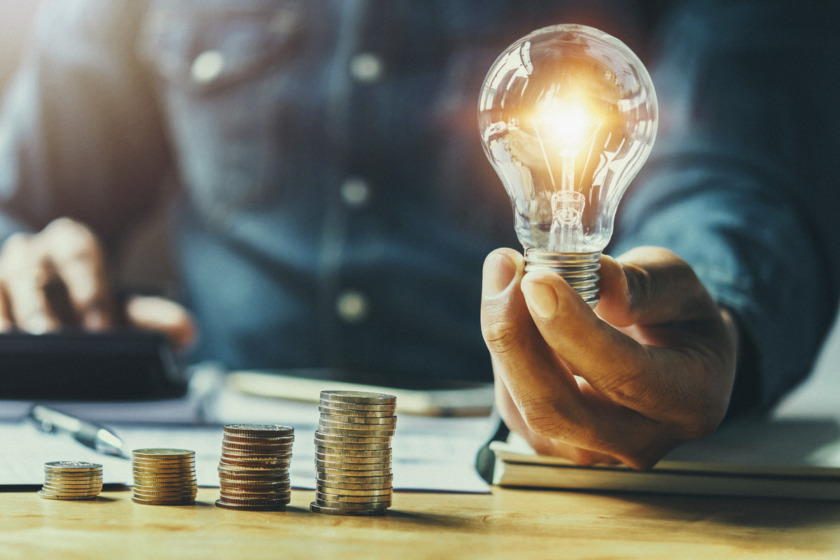 business man hand holding lightbulb with using calculator to cal